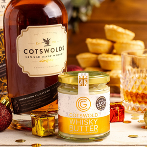 Bottle of Cotswolds Single Malt Whisky with a jar of Cotswold Whisky Butter on a festive background.